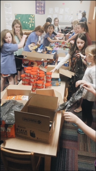 Girls eager to reach the goal of packing 95 food bags!