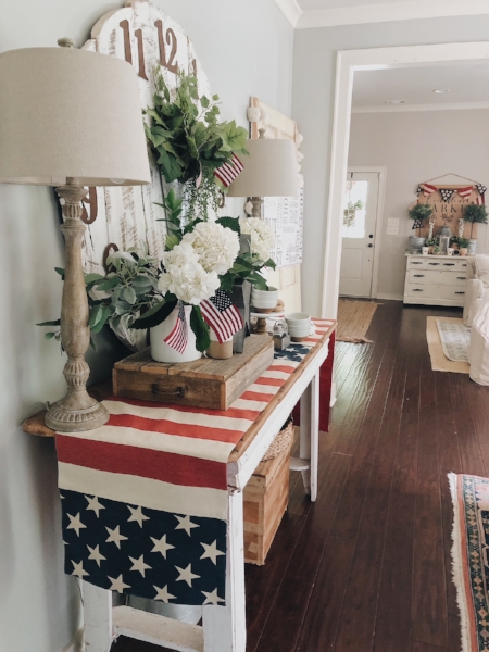 Patriotic table runner and flags make this space summer ready. The jute runner in entryway area is one of the most asked about pieces in this space, you can read more about where to find similiar ones here .