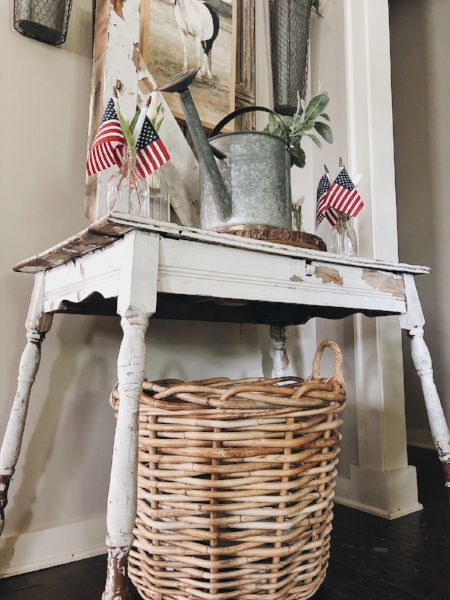 Patriotic decor on foyer table with flags.
