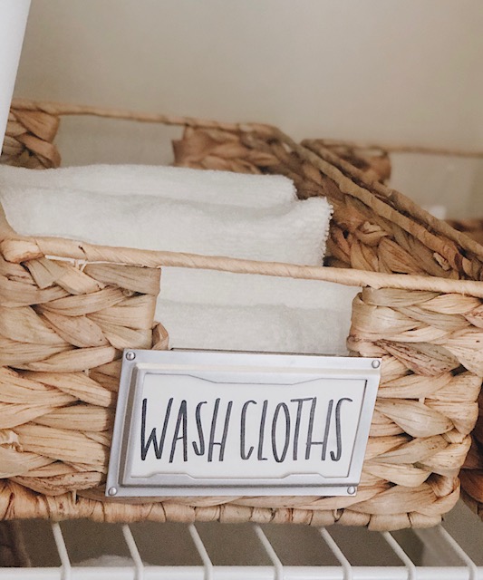 How To Create Organize Your Bathroom Closet, tips featured by top AL home blogger, She Gave It A Go. | How to Organize a Bathroom Closet by popular Alabama lifestyle blog, She Gave It A Go: image of a bathroom closet organized with woven seagrass basket and white plastic bins. 
