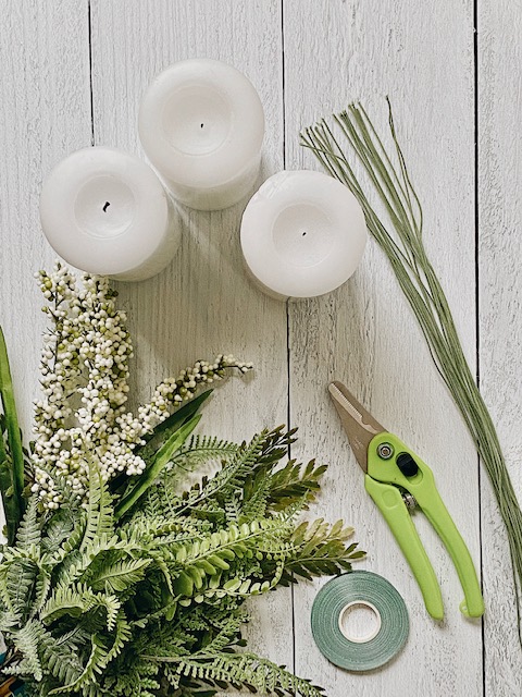 Cool DIY Summer Candle Rings, a Tutorial featured by top AL home blogger, She Gave It A Go | Candle Rings by popular Alabama DIY blog, She Gave It A Go: image of three white pillar candles, floral wire, green handle wire cutters, and faux greenery. 