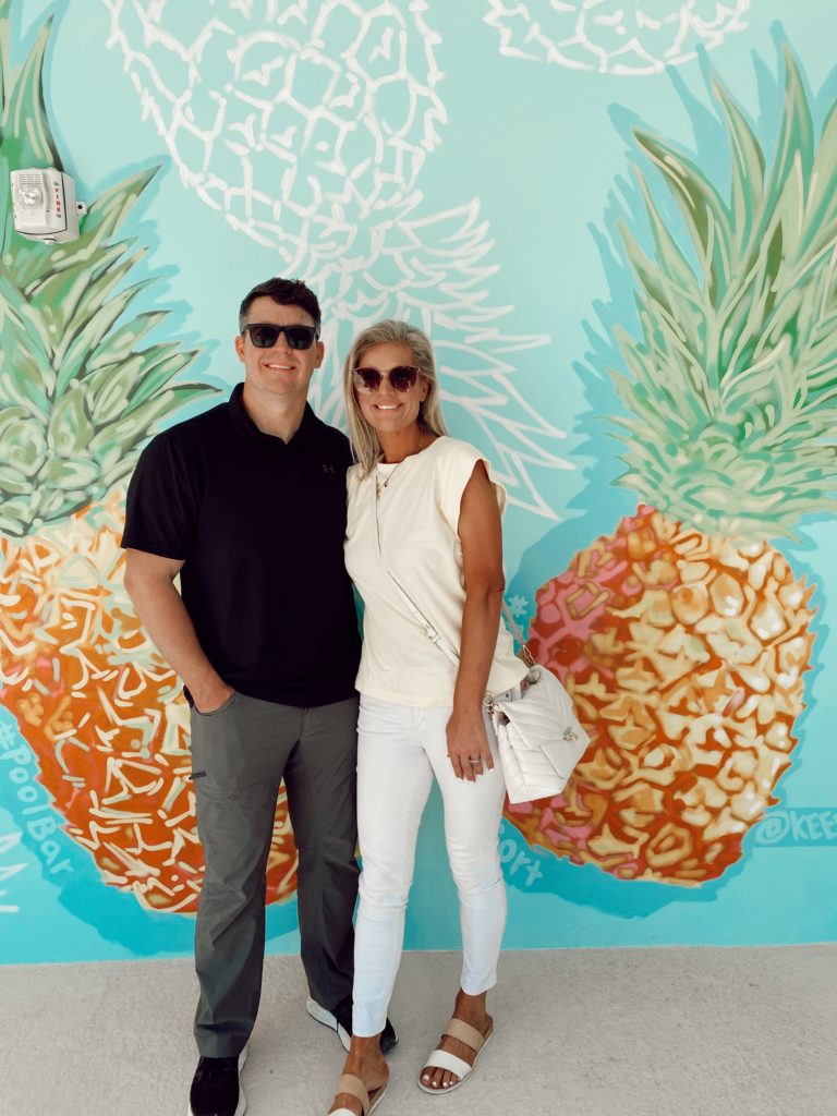 The Best Things to Do in Key Largo for Couples, a travel guide featured by top US travel blogger, She Gave It A Go | Things to do in Key Largo by popular Alabama travel blog, She Gave It A Go: image of a couple standing in front of a pineapple mural. 