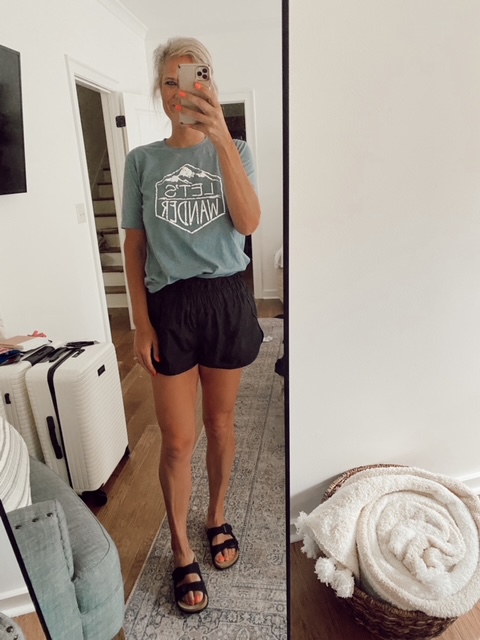 Welcome Home Saturday, a home decor blogging series featured by top AL home blogger, She Gave It A Go | Welcome Home Saturday by popular Alabama life and style blog, She Gave It A Go: image of a woman wearing a Let's Wander t-shirt, black pull on shorts, and black slide sandals. 