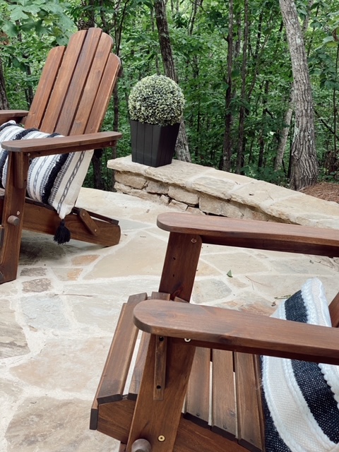Family Patio Ideas for summer featured by top AL home blogger, She Gave It A Go |  Family Patio Ideas by popular Alabama life and style blog, She Gave It A Go: image of two wooden patio chairs with black and white tassel lumbar pillow next to a topiary plant in a black planter. 