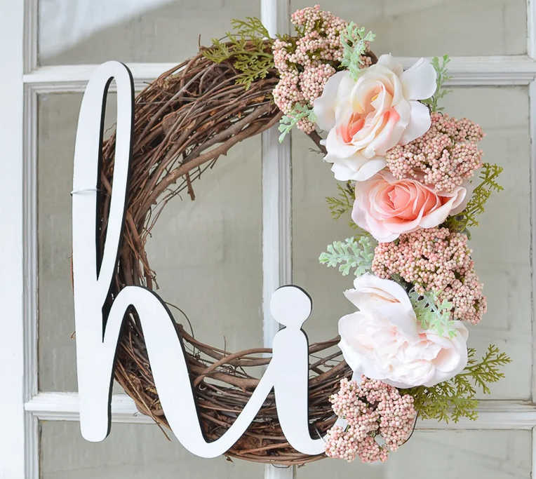 7 Rustic Farmhouse Wreath Ideas for your Summer Front Porch featured by top AL home blogger, She Gave It A Go | Farmhouse Wreath Ideas by popular Alabama life and style blog, She Gave It A Go: image of a twig wreath with faux pink roses and greenery stems and a white wooden 'Hi' sign. 
