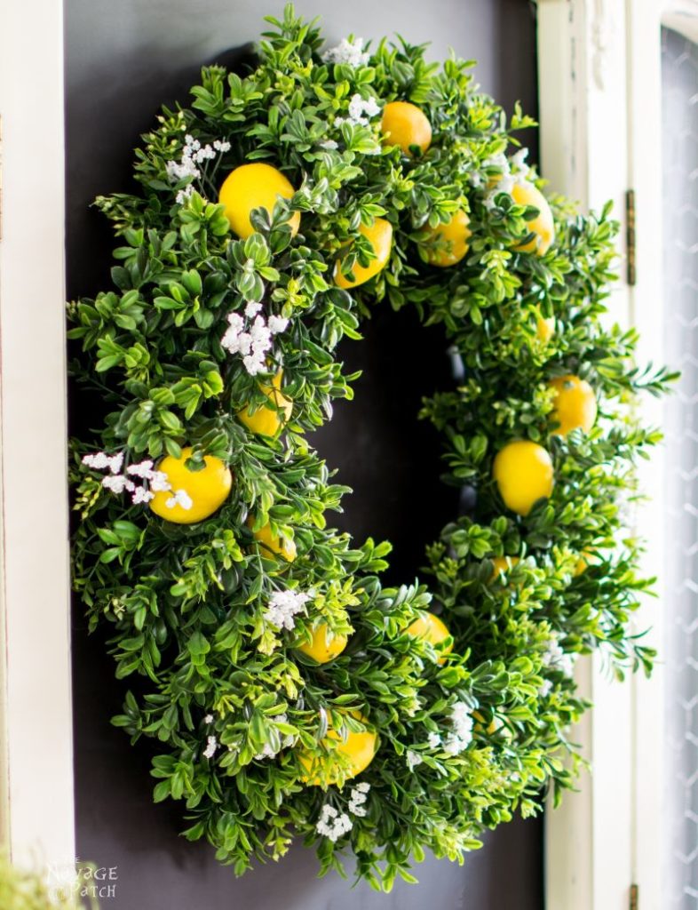 7 Rustic Farmhouse Wreath Ideas for your Summer Front Porch featured by top AL home blogger, She Gave It A Go | Farmhouse Wreath Ideas by popular Alabama life and style blog, She Gave It A Go: image of a faux boxwood and lemon wreath. 