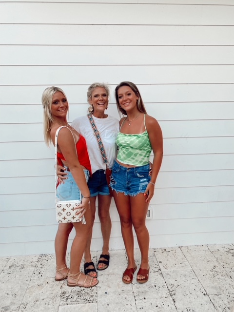 5 Essential Beach Vacation Tips for your Family featured by top AL family blogger, She Gave It a Go | Family Beach Vacation by popular Alabama travel blog, She Gave It A Go: image of three women standing together in front of a white building. 