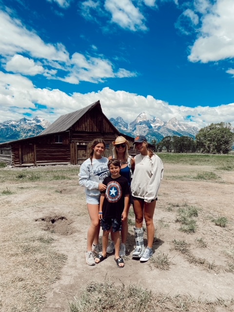 7 Best Things to Do in Jackson Hole with Teens featured by top AL family blogger, She Gave It A Go | Best Things to do in Jackson Hole by popular Alabama travel blog, She Gave it a Go: image of a family standing in front of a large wooden barn. 