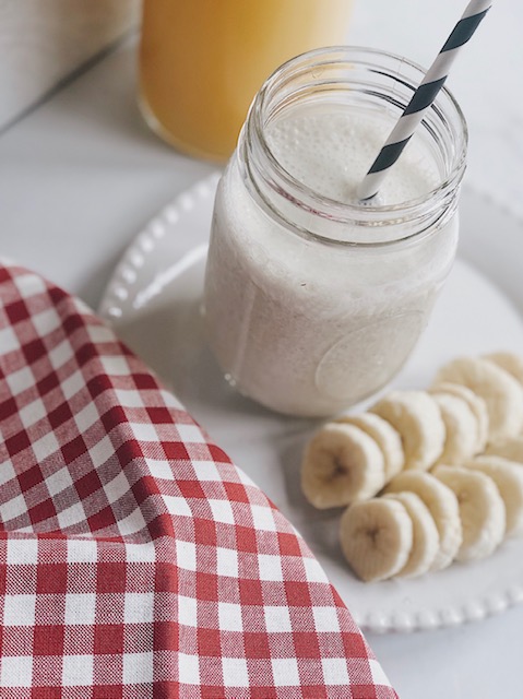 5 Easy Summer Smoothie Recipes featured by top AL lifestyle blogger, She Gave It A Go | Summer Smoothie Recipes by popular Alabama lifestyle blog, She Gave It A Go: image of a banana peach smoothie on a white plate next to some banana slices. 