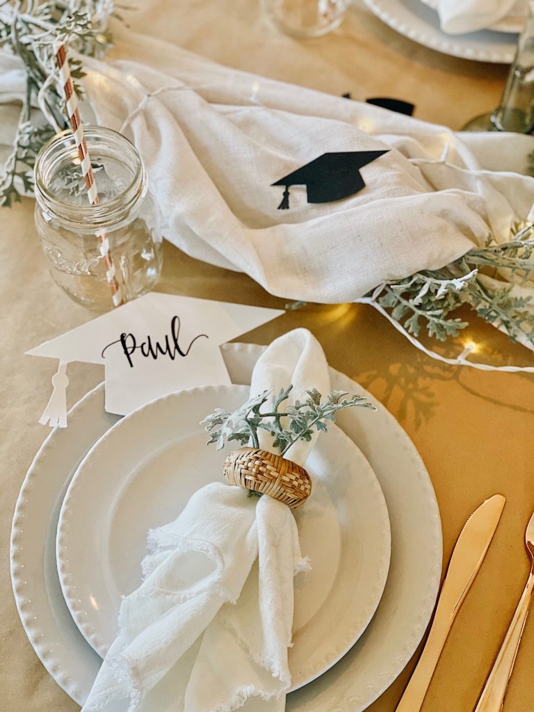 table setting with paper grad hats that is part of the graduation party centerpiece ideas