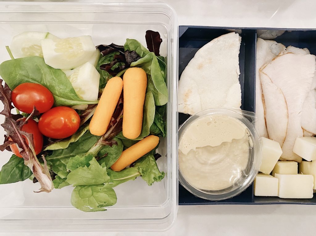 easy lunch box idea with turkey, hummus, salad, and pita bread