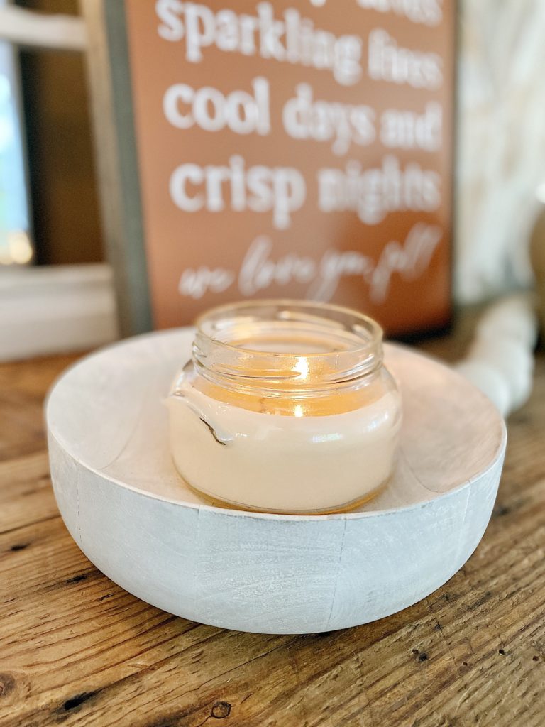 glass candle in wood bowl