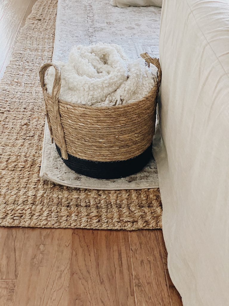woven seagrass basket holding a blanket