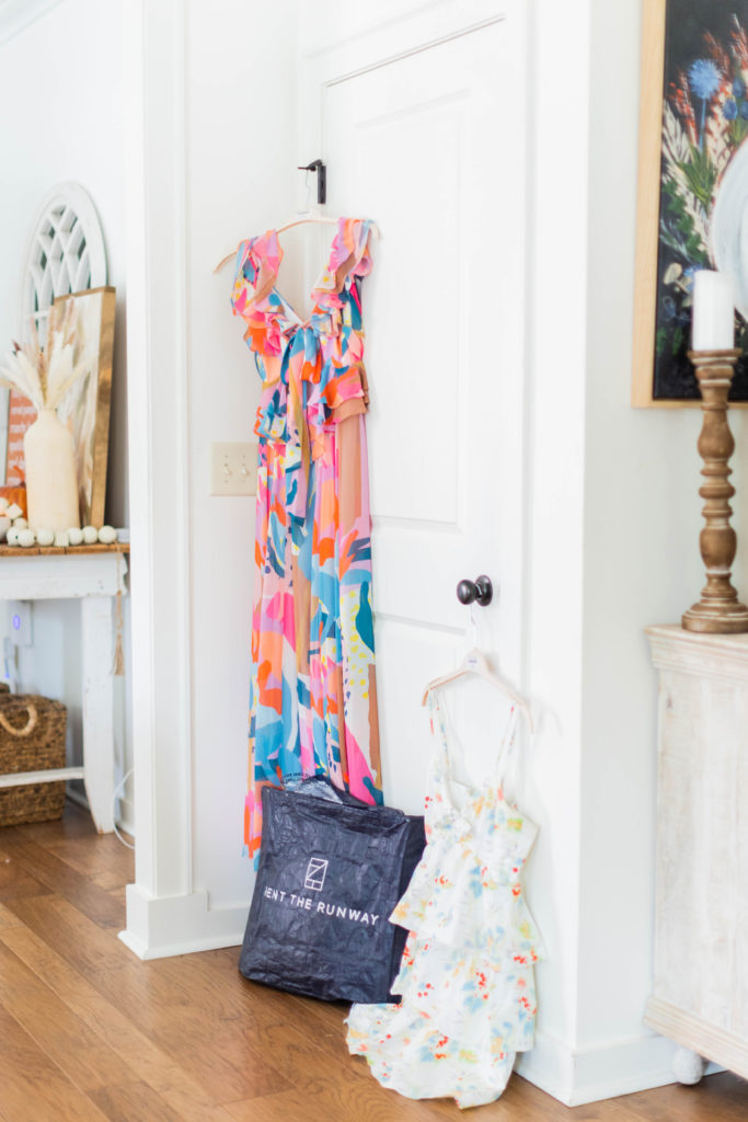 dresses hanging in a hallway with rent the runway bag