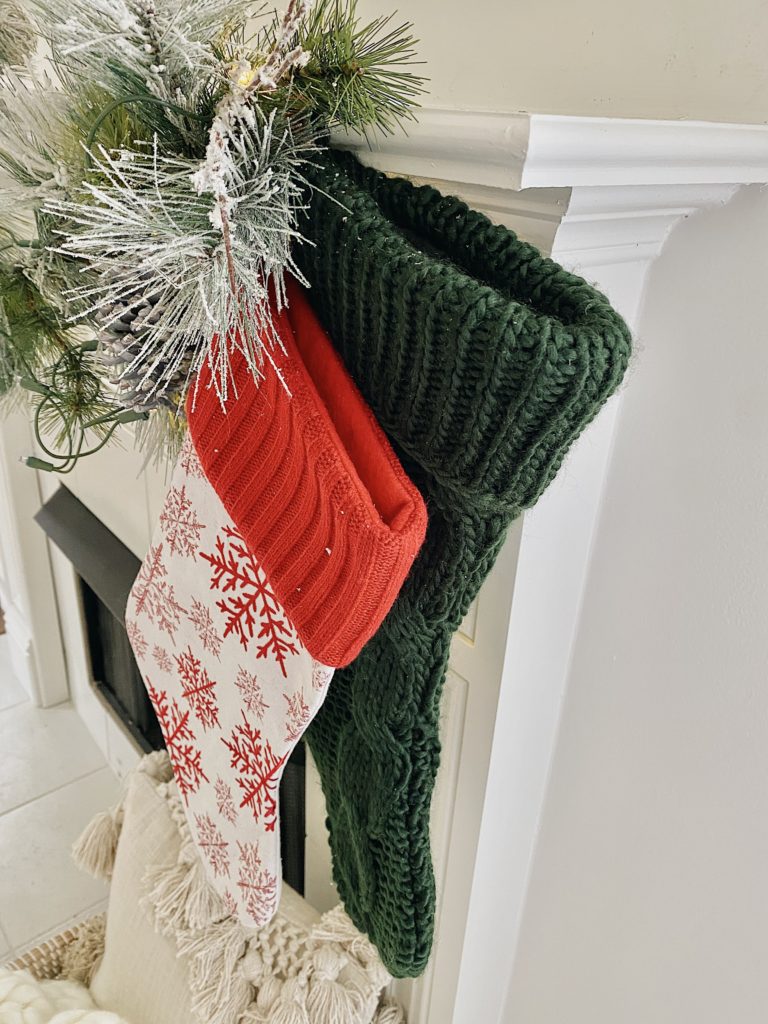 two stockings are hung on the mantel with a command hook