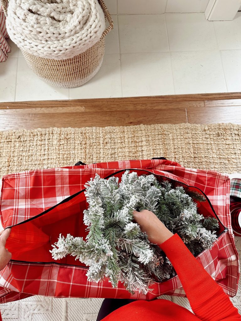 upward view of Christmas tree being placed inside storage bag.