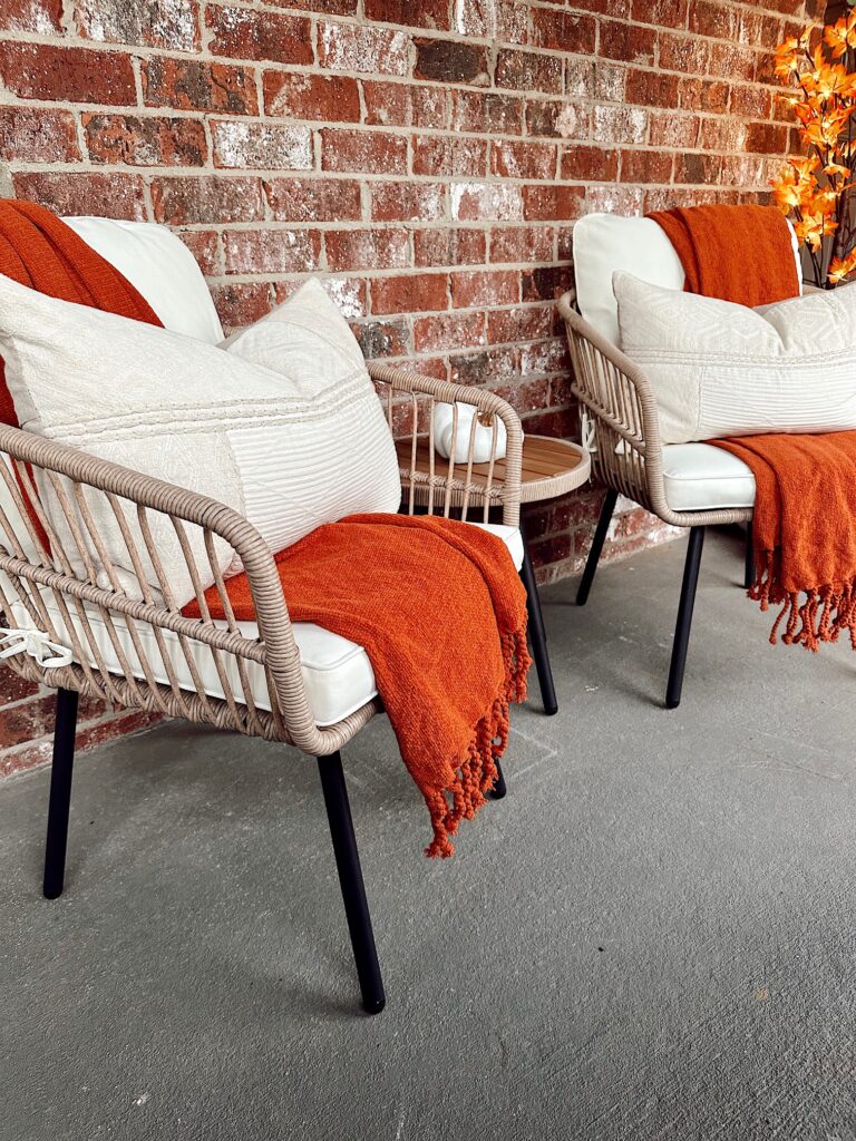 two patio chairs with small table decorated for fall