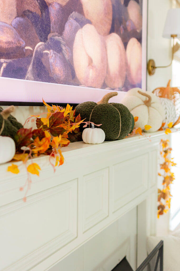 up close of pumpkins on the mantel and fall garland