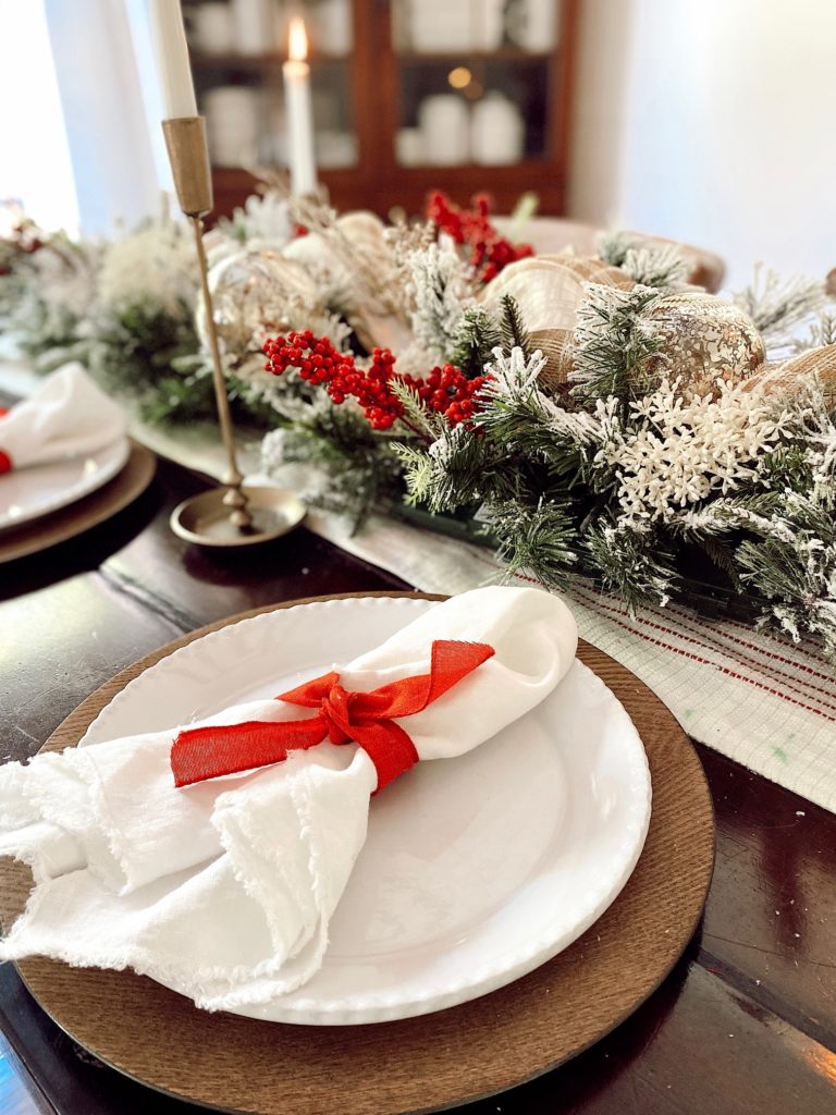close up of christmas centerpiece with napkins, plates and chargers