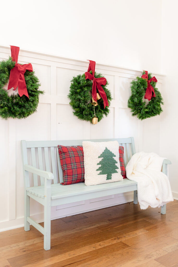 entryway with wreaths and blue bench and christmas pillows 