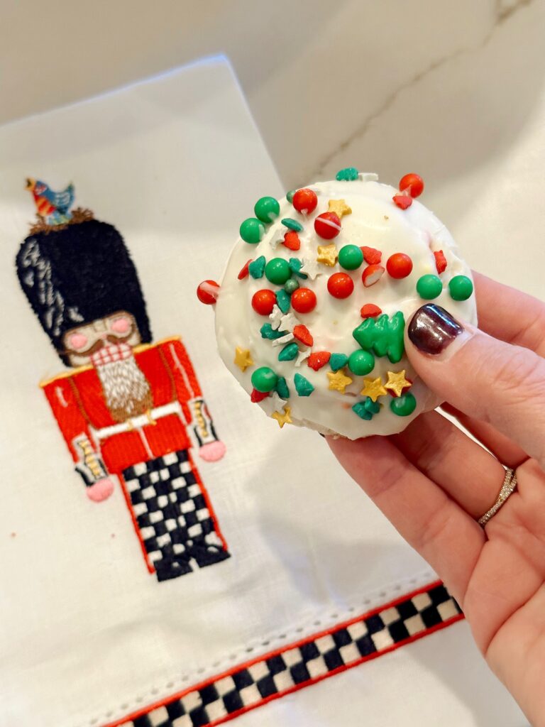 holding the iced sugar cookie above a nutcracker towel
