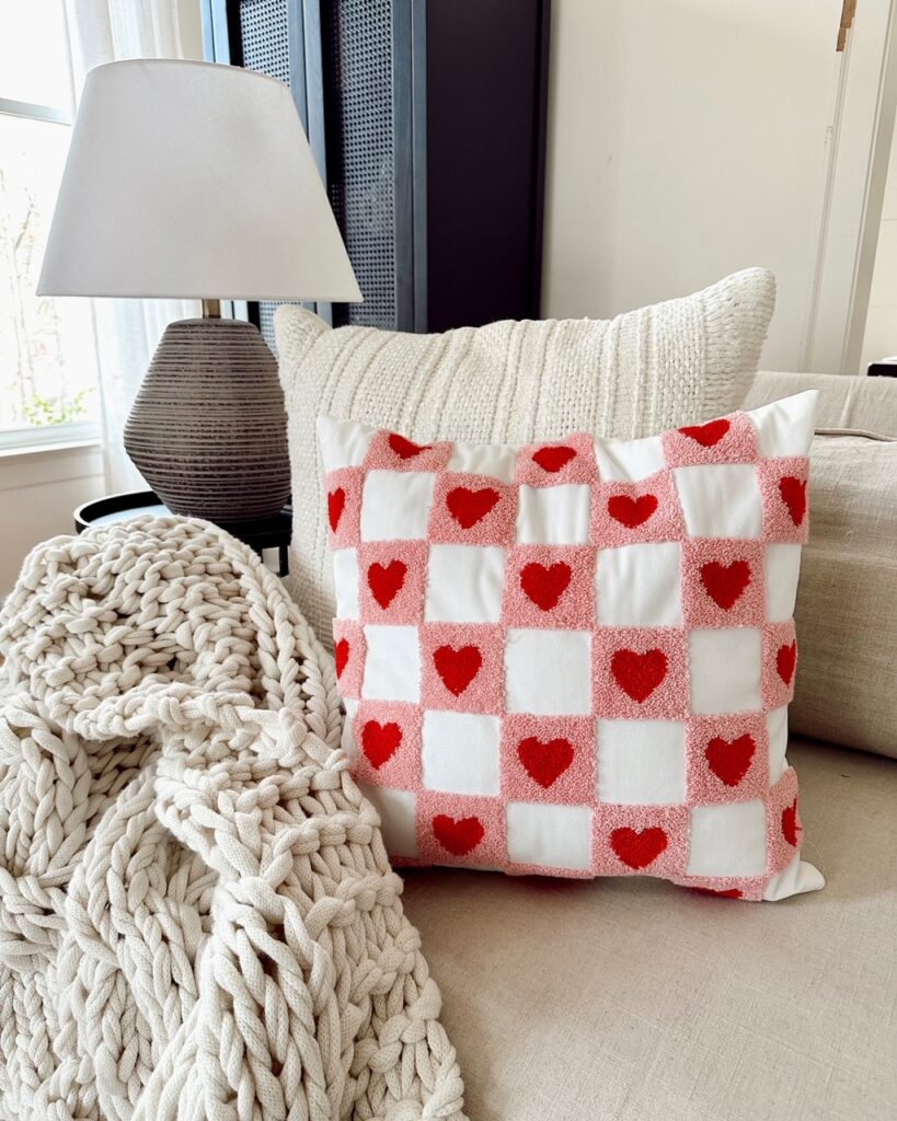 red and pink check pillow on sofa with blanket for Valentine's Day decor